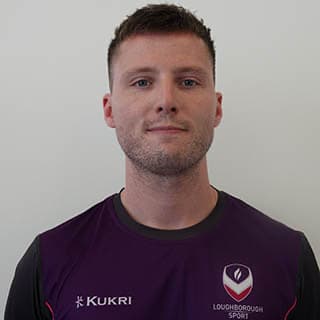 Ryan s wearing a Loughborough Sport top, and is smiling for a headshot.